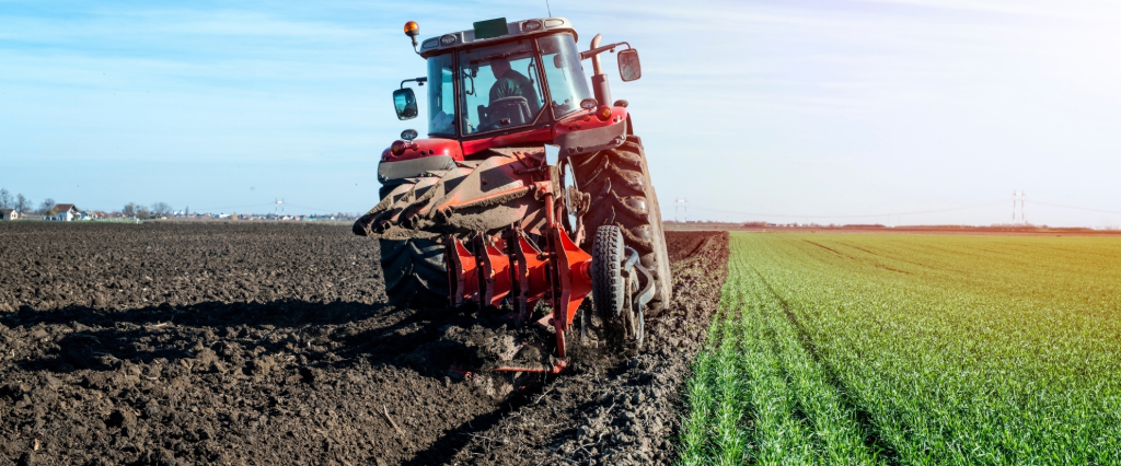 Tracteur labourant le sol avec une herse